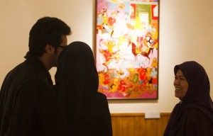Zohre Etezadolsaltaneh (R),49, speaks with visitors at her painting exhibition in Tehran January 23, 2011. Etezadolsaltaneh, a retired special education teacher, was born with no arms but lives the life of an independent woman who has been doing cooking, painting, weaving kilims and taking care for her mother who is a cancer patient. She gets $600 per month as pension from the government and lives by the mantra "To want is to succeed". Picture taken January 23, 2011. REUTERS/Raheb Homavandi  (IRAN - Tags: SOCIETY)