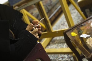 Zohre Etezadolsaltaneh, 49, opens a tube of paint using her feet as she works on a painting at her home in Tehran January 24, 2011. Etezadolsaltaneh, a retired special education teacher, was born with no arms but lives the life of an independent woman who has been doing cooking, painting, weaving kilims and taking care for her mother who is a cancer patient. She gets $600 per month as pension from the government and lives by the mantra "To want is to succeed". REUTERS/Raheb Homavandi  (IRAN - Tags: SOCIETY)