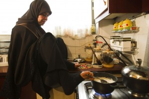 Zohre Etezadolsaltaneh, 49, cooks a meal using her foot at her home in Tehran January 24, 2011. Etezadolsaltaneh, a retired special education teacher, was born with no arms but lives the life of an independent woman who has been doing cooking, painting, weaving kilims and taking care for her mother who is a cancer patient. She gets $600 per month as pension from the government and lives by the mantra "To want is to succeed.". REUTERS/Raheb Homavandi  (IRAN - Tags: SOCIETY IMAGES OF THE DAY)